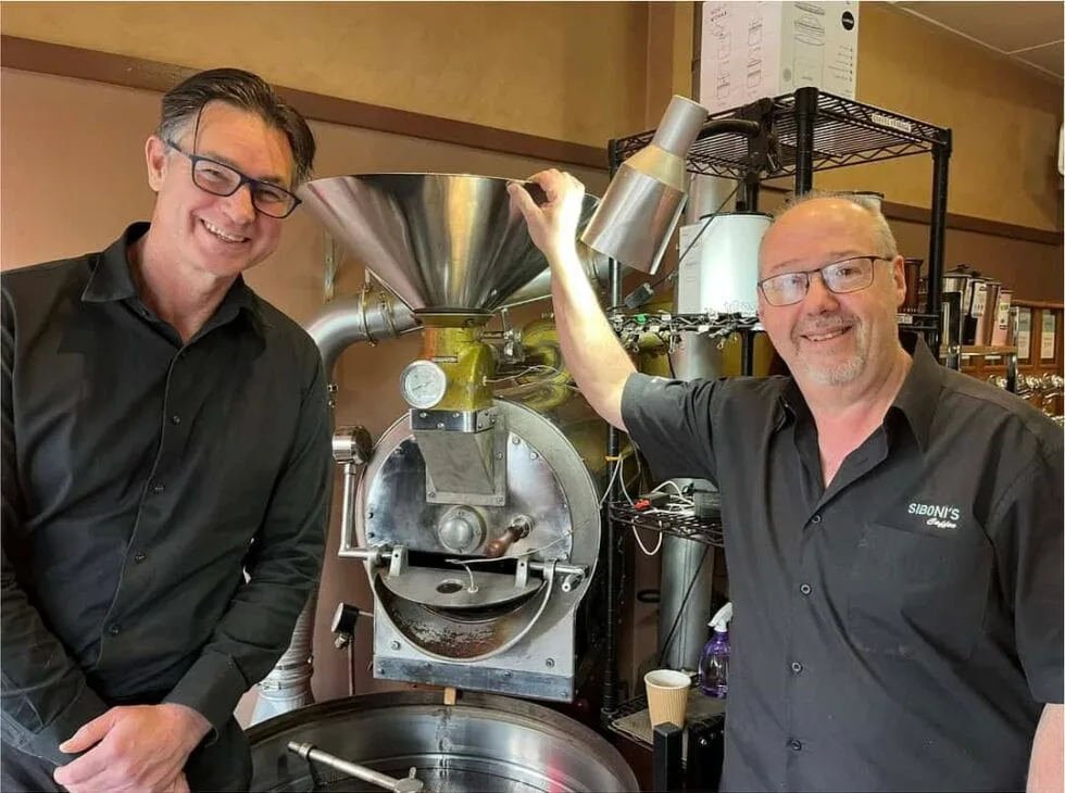Andrew Brown and the Siboni's Coffee team beside the roaster